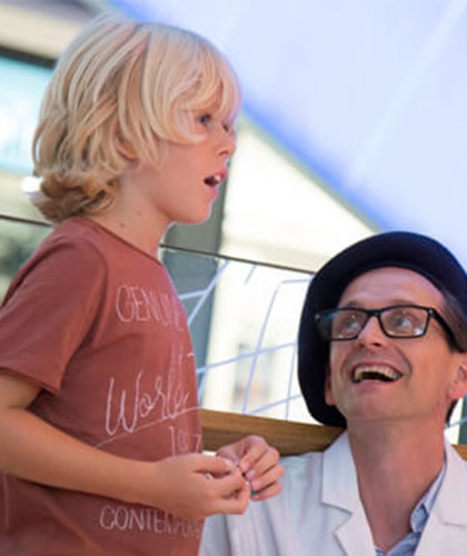 Ein Schauspieler agiert mit Publikum im Einkaufscenter-Ein Schauspieler dekoriert eine Living Doll Puppe im Einkaufscenter